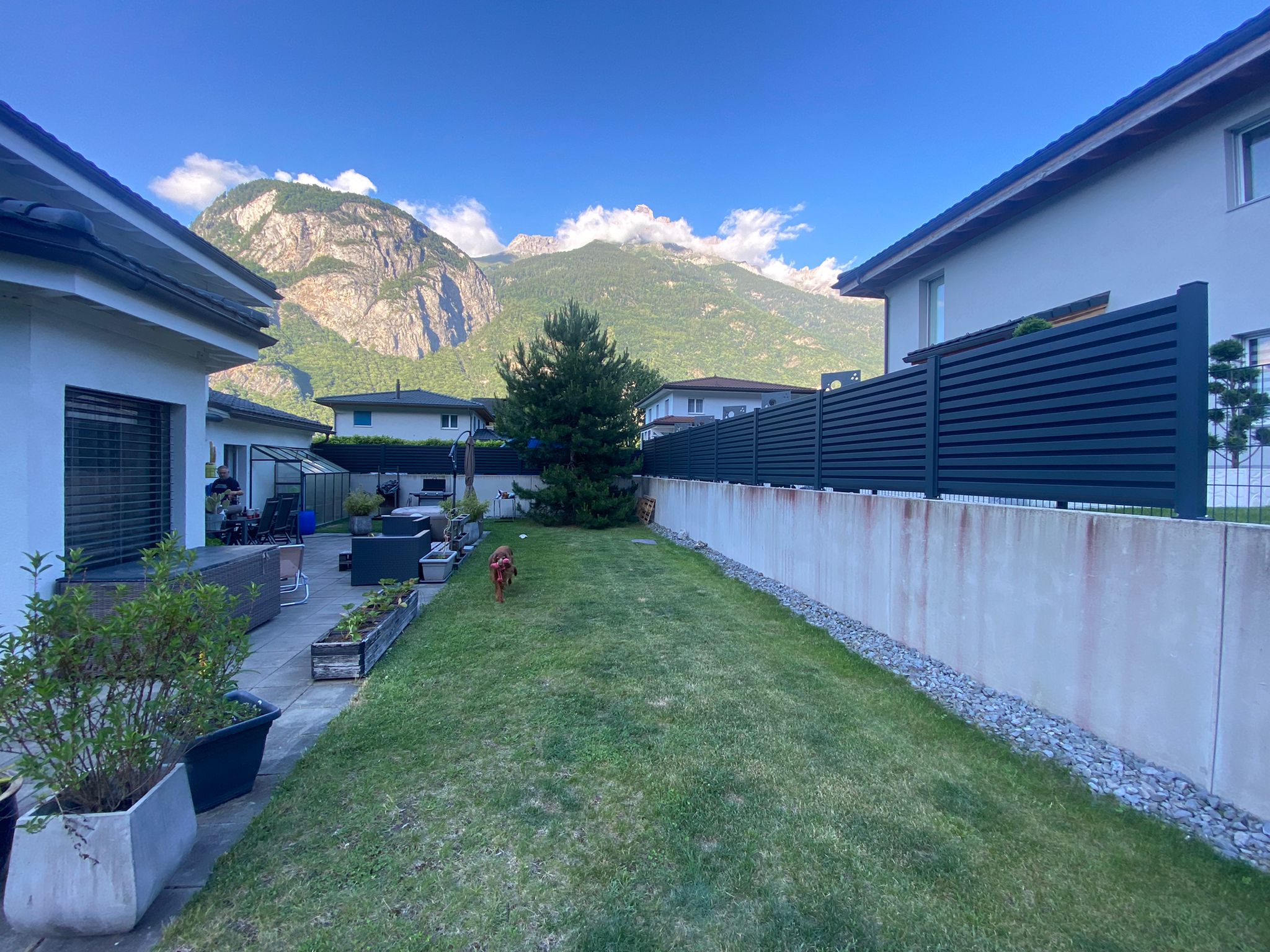 Jardin verdoyant idéal pour installation portail, clôture et motorisation professionnelle Suisse.