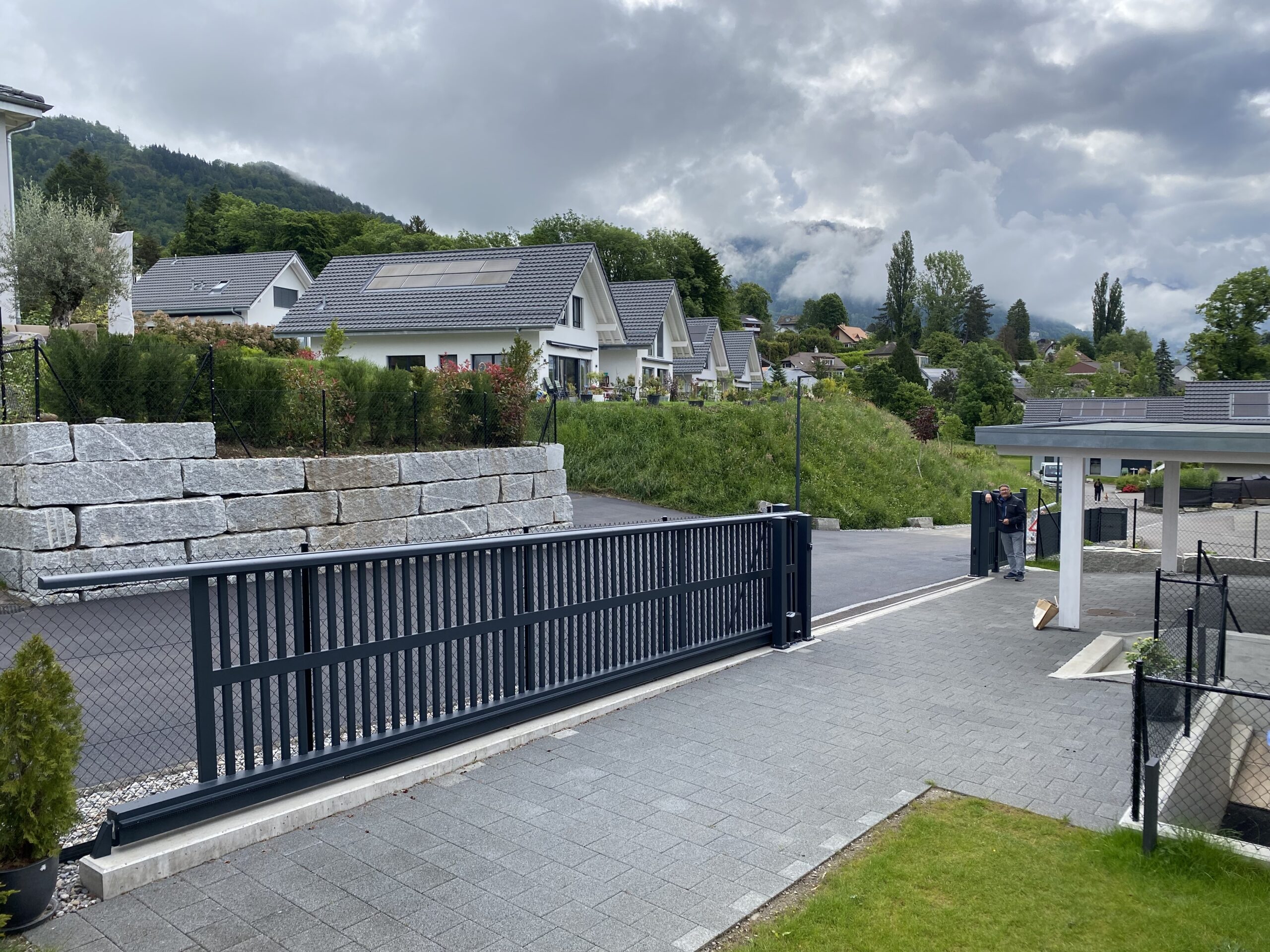 Portail extérieur motorisé sécurisé avec muret, installation professionnelle suisse.