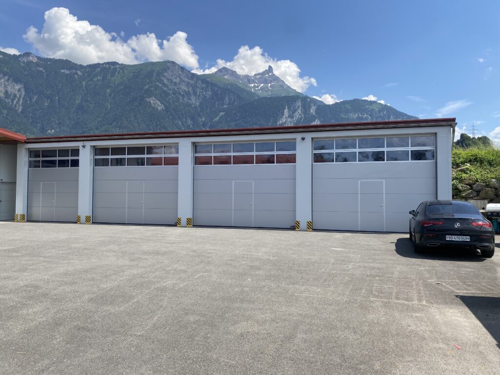 Portes de garage industrielles posées en Suisse, installation portail extérieur professionnelle.