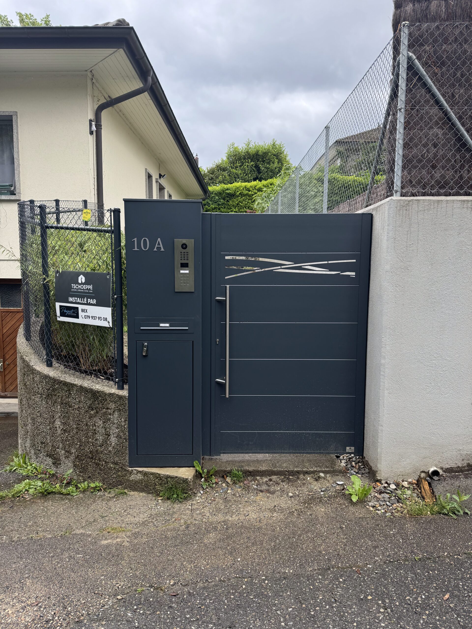 Portail moderne gris foncé 10A avec interphone, boîte aux lettres, installation sécurisée suisse.