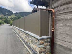Clôture extérieure en bois installée sur muret, façade suisse professionnelle.