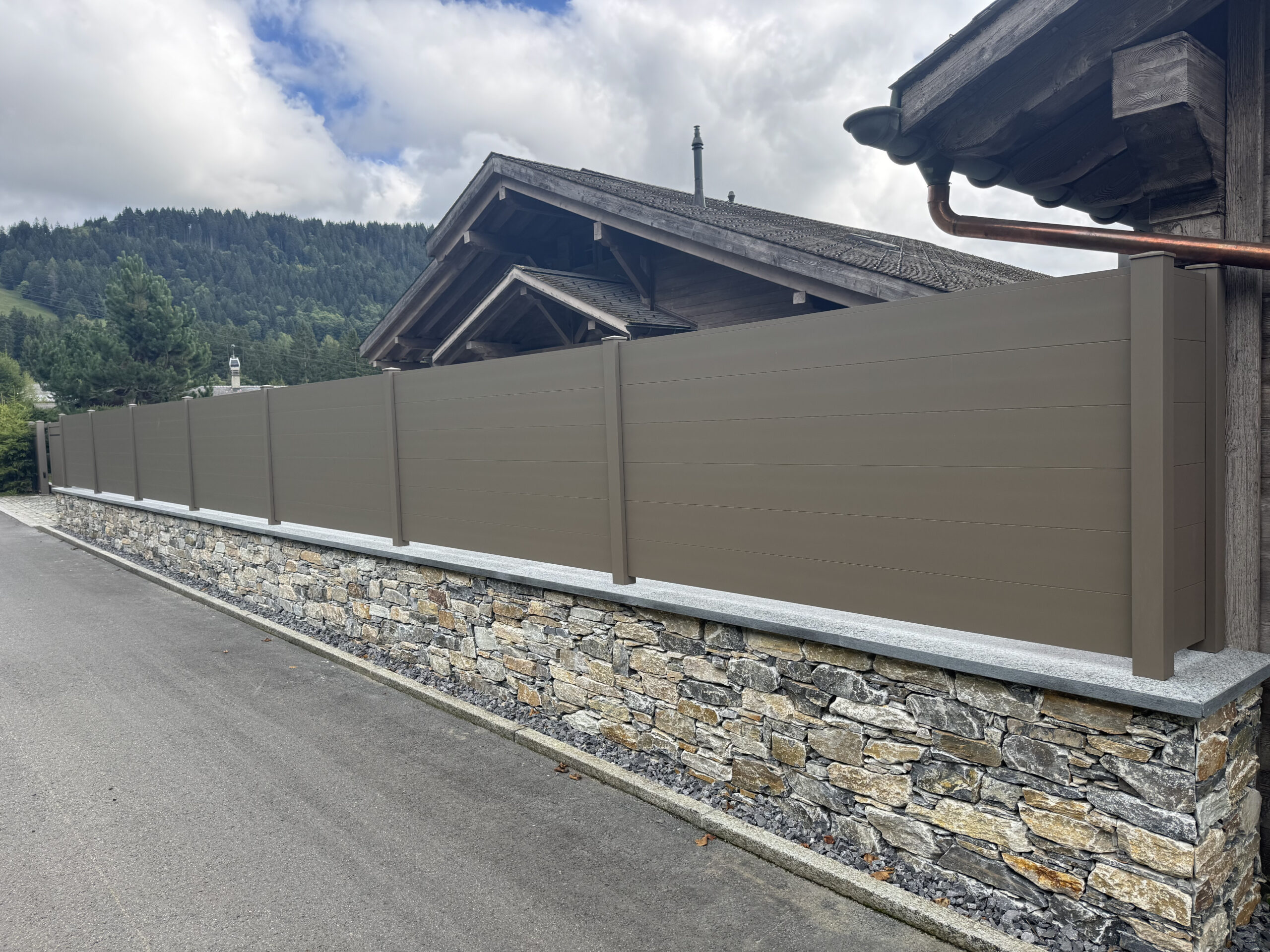 Clôture moderne sur muret, installation extérieure suisse, portail professionnel.