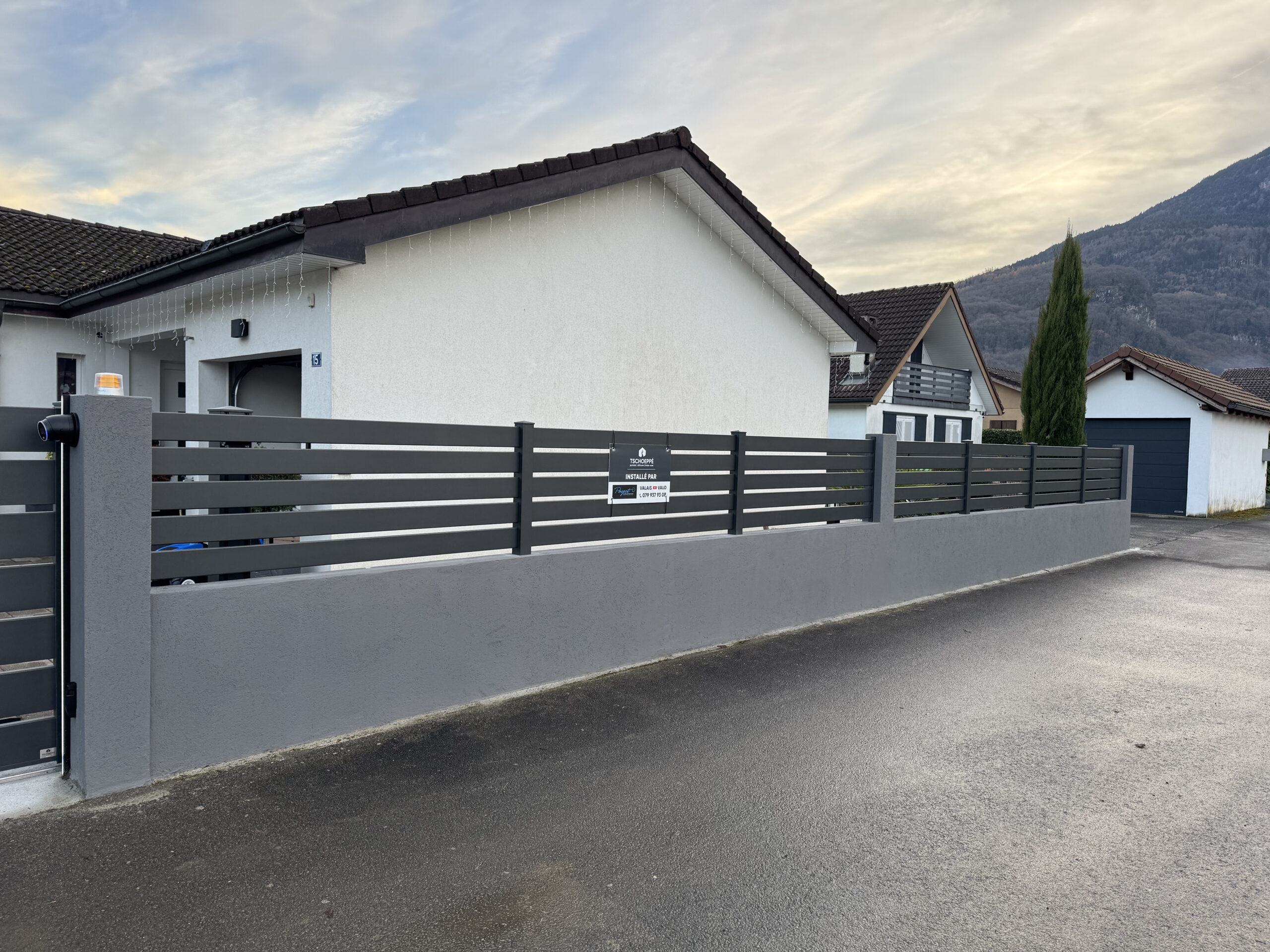 Maison moderne avec portail extérieur aluminium, motorisation, installation et entretien en Suisse.