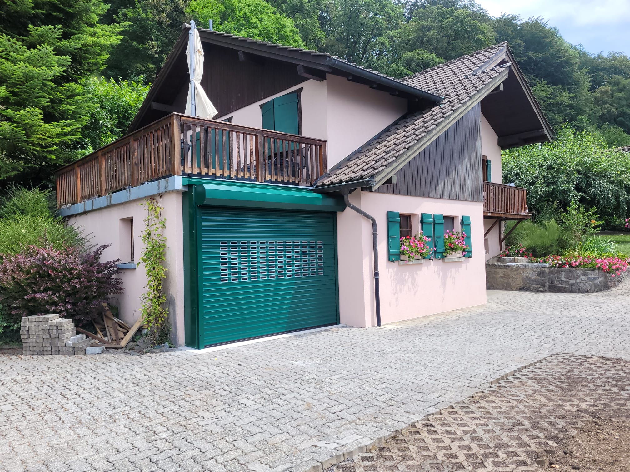 Maison rose, portail extérieur, porte de garage verte : installation experte suisse.