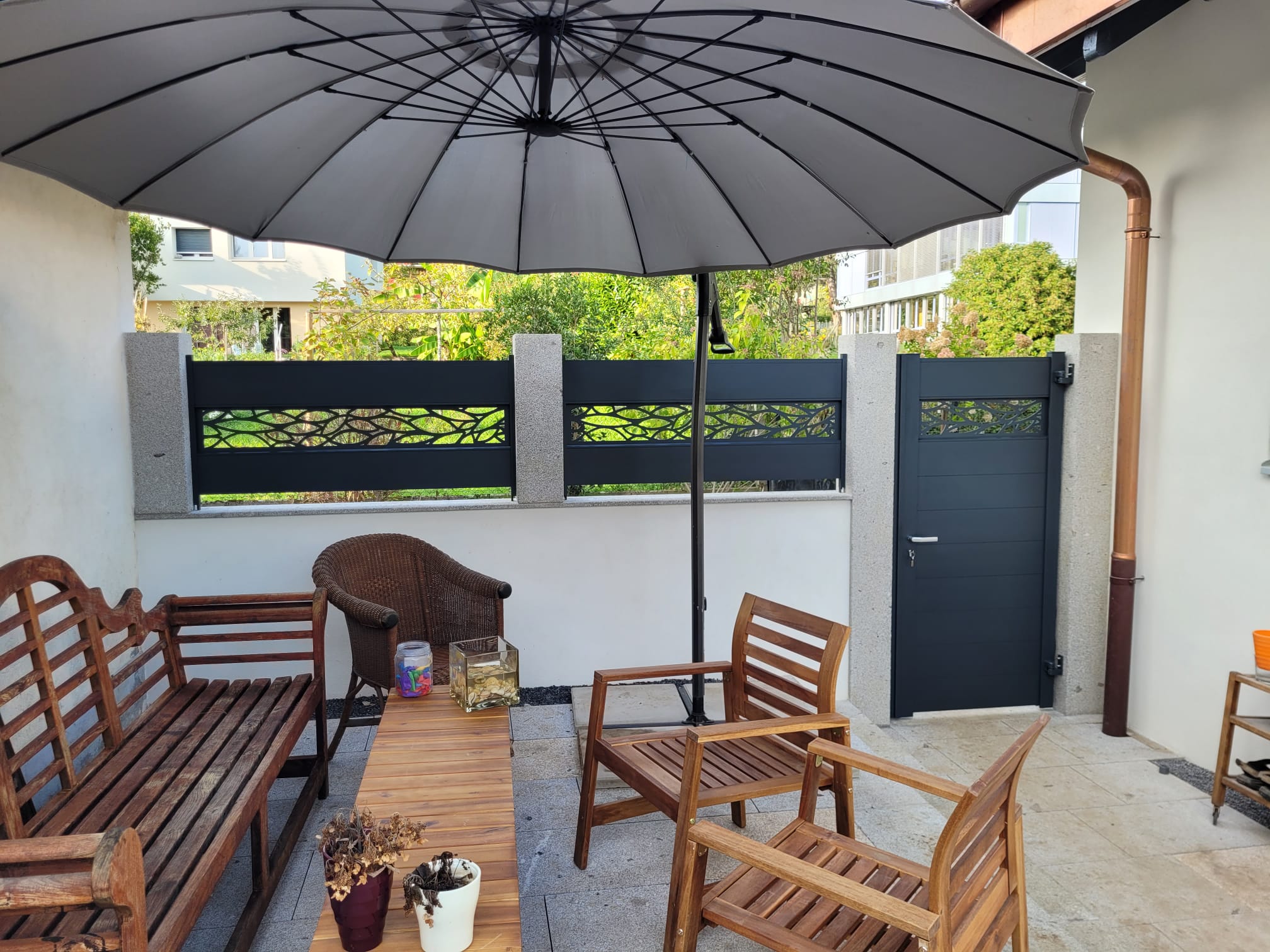 Installation de portail extérieur suisse, clôture design et terrasse aménagée.