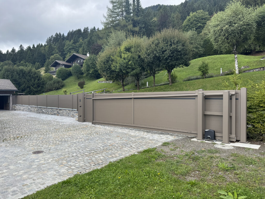 portail coulissant moderne brun, allée pavée, parfait pour extérieurs résidentiels suisses.