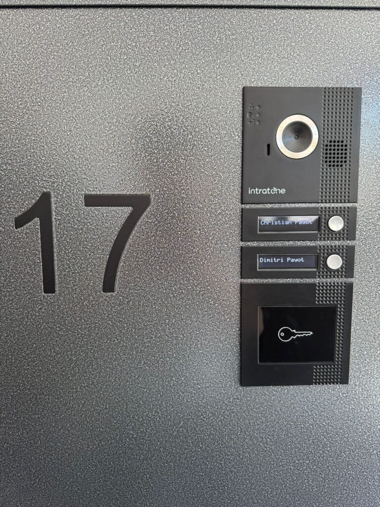 porte métallique grise sécurisée avec interphone caméra et accès badge, idéale pour ouvertures extérieures en suisse.